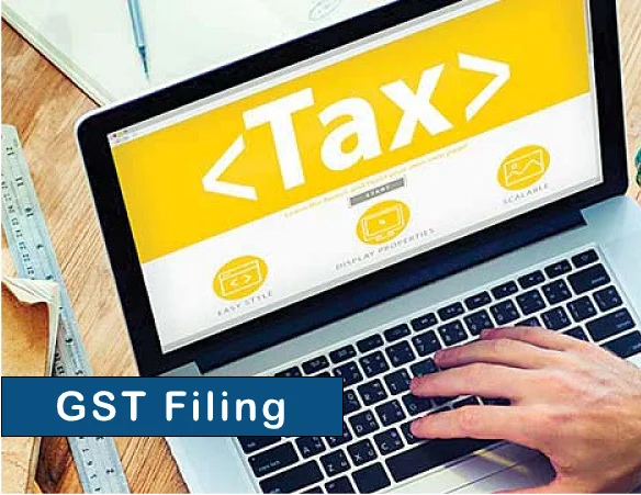 The image shows the hand of the person working on the laptop and the text " GST Filling" with a blue background.
